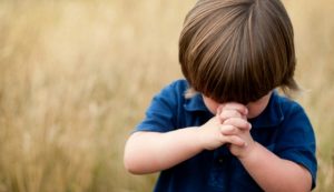 child praying for forgiveness