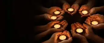 Many hands holding small lights together, illustrating whether spiritual gifts are for today