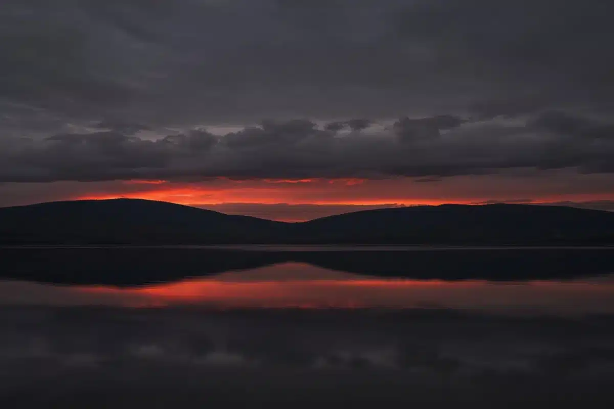A dark lake at dusk with a red glow, picturing the second death and the lake of fire
